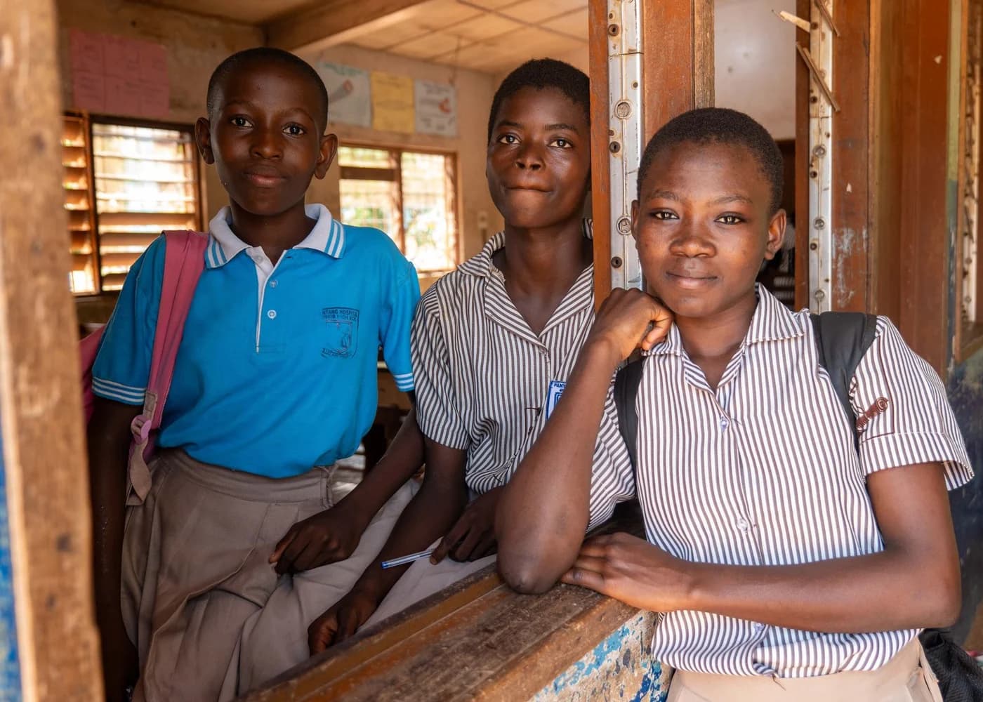 Three secondary school students in a classroom in Ghana